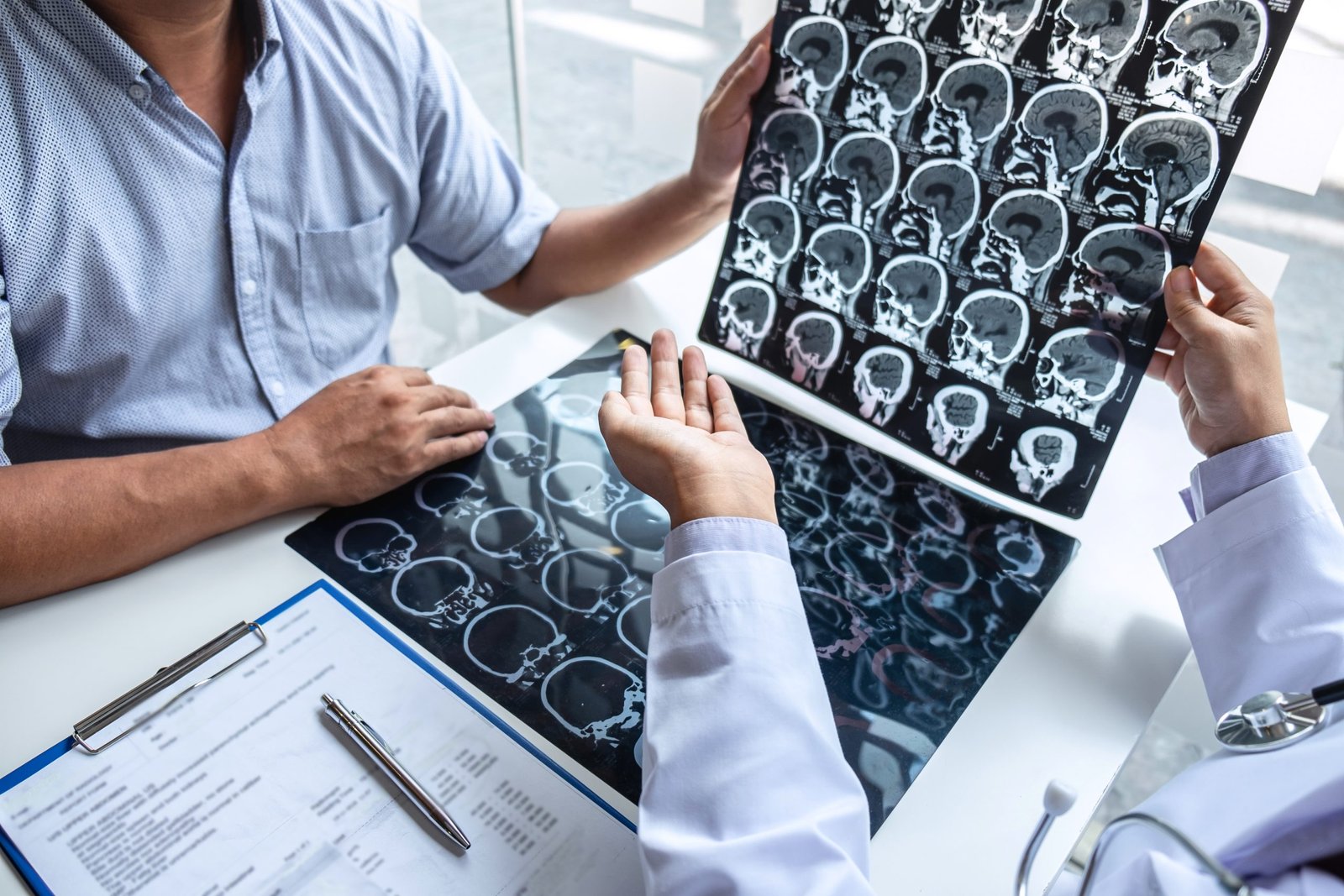 doctor holding looking x ray film examining brain by ct scan patient analyze result while discussing explaining problem medical scaled