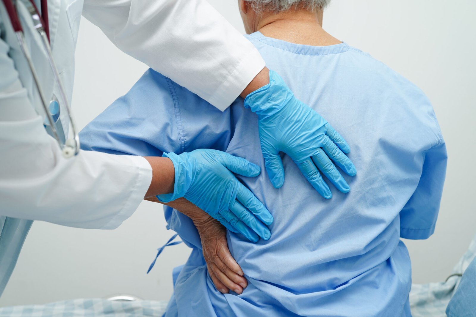 doctor examine treat asian elderly patient muscle back pain problem physical therapy hospital scaled
